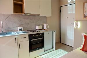 a kitchen with a sink and a stove top oven at Best House Erato Neo Faliro Piraeus in Piraeus