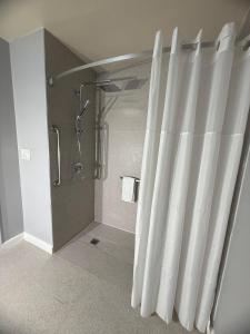 a bathroom with a shower and a shower curtain at Naval Suites by FairBridge in Bremerton