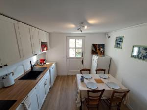 a kitchen with a table with chairs and a refrigerator at Appartement proche Château de Compiègne in Compiègne