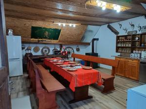 a dining room with a red table in a kitchen at Guest House Марковата Къща in Madzhare