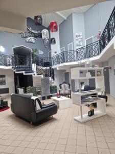 a living room with a couch and chairs and stairs at Agape Hotel Niort- Bessines in Bessines