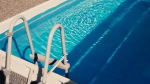 a swimming pool with blue water and rails in it at La Kaz Eden * * * * in Les Cocos