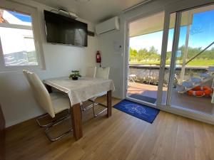 a dining room with a table and chairs and a balcony at Hausboot Pula - Floating House Water Lily in Pula