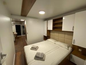 a bedroom with a bed with two towels on it at Hausboot Pula - Floating House Water Lily in Pula