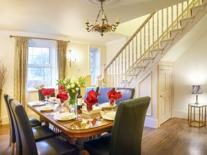 a dining room with a table with red flowers on it at The Hind House in Cowlam +32 photos