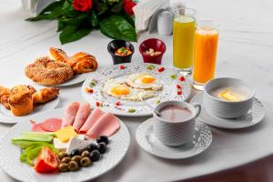 a table with plates of breakfast foods and drinks at Hotel Square Plaza At Airport in New Delhi +26 photos