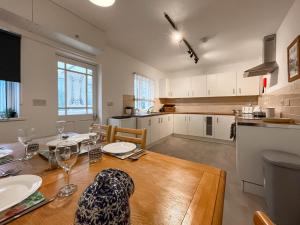 a kitchen and dining room with a wooden table and chairs at 6 Mill Road in Okehampton