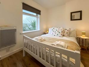 a white bed in a room with a window at 6 Mill Road in Okehampton