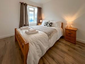 a bedroom with a large bed with two towels on it at 6 Mill Road in Okehampton