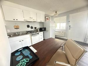 a kitchen with a wooden table and a kitchen with white cabinets at Naval Suites by FairBridge in Bremerton +34 photos