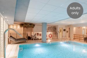 an indoor pool in a hotel with the words adults only at Hotel Relais Vecchio Maso in Trento