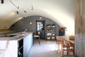 an attic kitchen with an archway and a kitchen island at Château de Lemps in Lemps