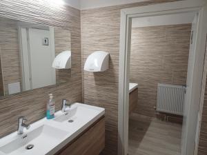 a bathroom with two sinks and a mirror at Pensiunea CARLA in Sărata-Monteoru +139 photos