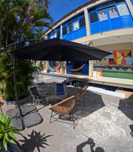 an umbrella and chairs in front of a swimming pool at Nomads Hostel Multicultural & Coworking in Salvador +114 photos