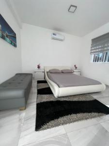 a white bedroom with a bed and a rug at Coraçon di Mindel Apartment in Mindelo