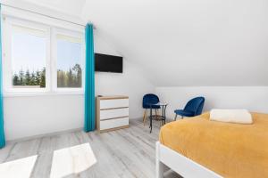 a bedroom with a bed and a tv on a wall at Halinówka Goniądz in Goniadz