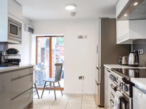 a kitchen with a door leading to a balcony at Mill House Barn in Warmingham