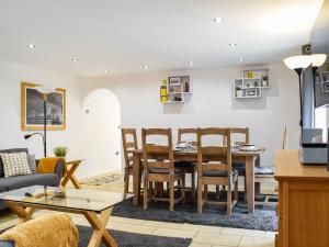 a living room and dining room with a table and chairs at Mill House Barn in Warmingham