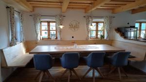 a kitchen with a large wooden table and blue chairs at Chalet Schmuckkastal in Kollnburg