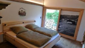 a bed in a room with a large window at Chalet Schmuckkastal in Kollnburg