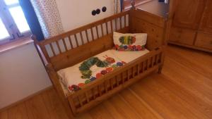 a wooden crib with two pillows in a room at Chalet Schmuckkastal in Kollnburg