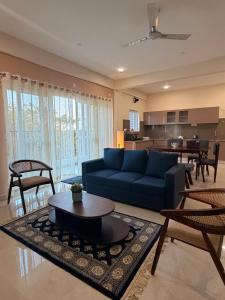 a living room with a blue couch and a table at Altura in Bangalore