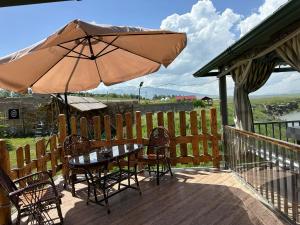 a table and chairs with an umbrella on a deck at Full Panorama Guest House in Aparan