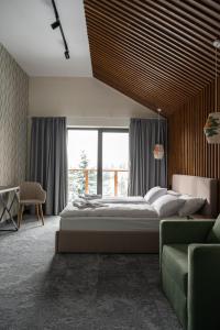 a bedroom with a large bed and a green couch at Gogodz Chalet Resort in Yablunytsya +100 photos