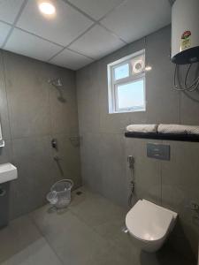a bathroom with a toilet and a shower and a window at Altura in Bangalore +22 photos