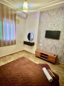 a living room with a flat screen tv and a rug at Apartment, well equipped in Fez +7 photos