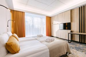 a hotel room with a large bed and a television at Aspen Prime Ski & Bike Resort - basen, sauna, jacuzzi, siłownia w cenie pobytu in Głuchołazy