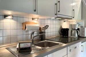 a kitchen with a sink and a tablet on the counter at Ole in Borgsum in Borgsum