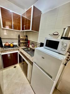 a kitchen with a white refrigerator and a microwave at Apartment, well equipped in Fez