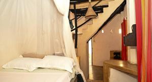 a bedroom with a bed with a white curtain at Wildebeeste Lamu in Lamu