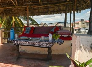 a red couch sitting on a table on a porch at Wildebeeste Lamu in Lamu +15 photos