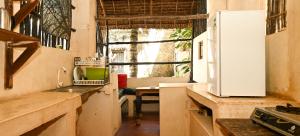 a kitchen with a sink and a refrigerator at Wildebeeste Lamu in Lamu