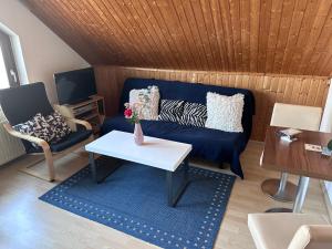 a living room with a blue couch and a table at Apel Apartments 1 in Nörten-Hardenberg
