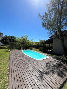 a swimming pool on top of a wooden deck at Rosa Olas Cabanas in Praia do Rosa