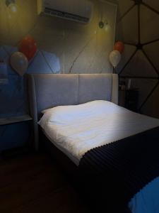 a bed in a room with balloons on the wall at Ghadi Domes in Nimrod