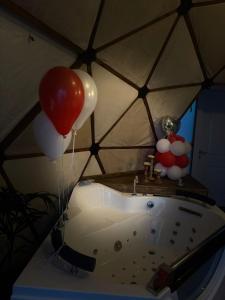 a room with a tub with balloons and a sink at Ghadi Domes in Nimrod