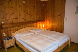 a bedroom with a large bed with a wooden wall at Haus Kristall in Bach