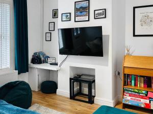a living room with a flat screen tv on a wall at Miner's Rest in Frizington