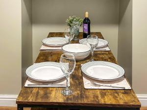 a table with plates and glasses and a bottle of wine at Miner's Rest in Frizington +13 photos