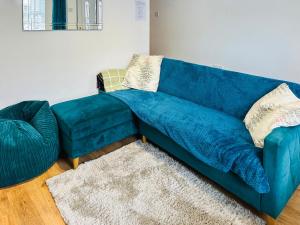 a blue couch and a chair in a living room at Miner's Rest in Frizington