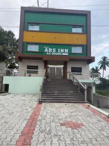 a building with stairs in front of a building at ars inn and mini hall in Tiruvallam