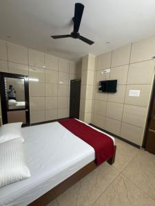 a bedroom with a bed with a ceiling fan at ars inn and mini hall in Tiruvallam