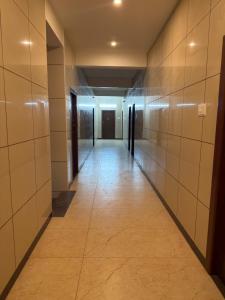 an empty hallway in a building with tile walls at ars inn and mini hall in Tiruvallam +1 photo
