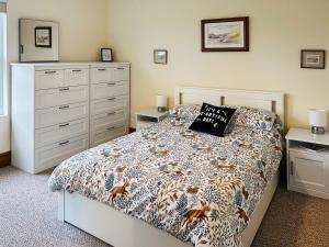 a bedroom with a bed and a dresser at Miner's Rest in Frizington