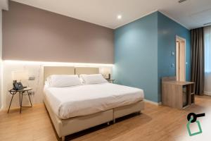 a bedroom with a white bed and a blue wall at Hotiday Lerici Porto in Lerici
