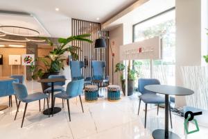 a waiting room with blue chairs and tables at Hotiday Lerici Porto in Lerici